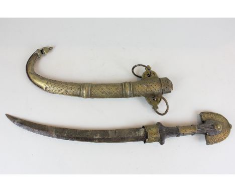 A North African jambiya dagger with gilt metal mounted handle, 29cm carved blade and scabbard, 45cm, (NC)