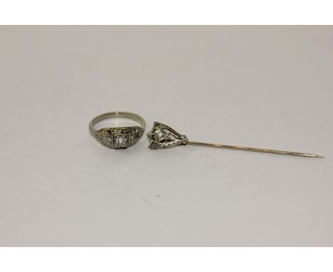 A diamond ring with a central brilliant cut and eight cut diamonds to the shoulders and a diamond stick pin