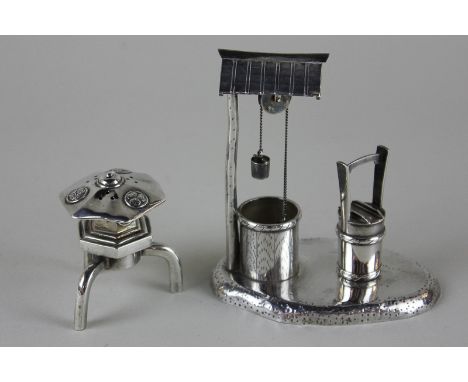 Two Chinese silver pepper pots, one in the shape of a well and the other as a pagoda on stand, both stamped sterling