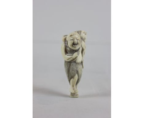 A 19th century carved ivory netsuke of a laughing fisherman with fish, 6cm tall, (NC)