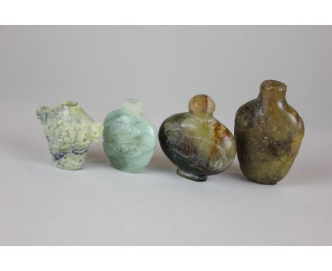 Three carved stone snuff bottles, one with a peacock (very worn), the other two primitively carved, together with a pale gree