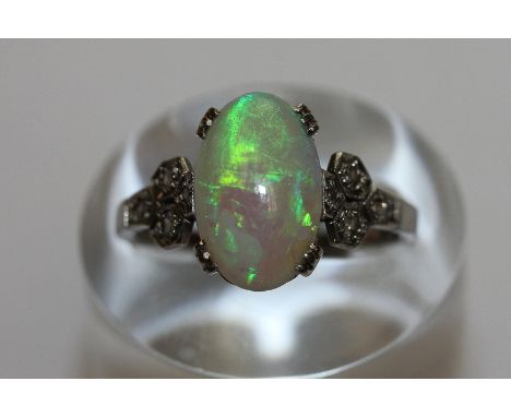 An opal and diamond ring the oval cabochon four triple claw set with four eight cut diamonds to each shoulder 