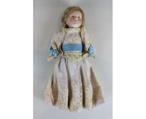 A Kamer and Reinhart porcelain head doll with blond hair, blue eyes and composite limbs, in lace dress with blue sash, 22cm, 