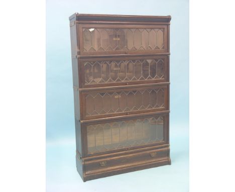 A dark oak Globe Wernicke bookcase, four glazed sections with base drawer, 2ft. 10in.