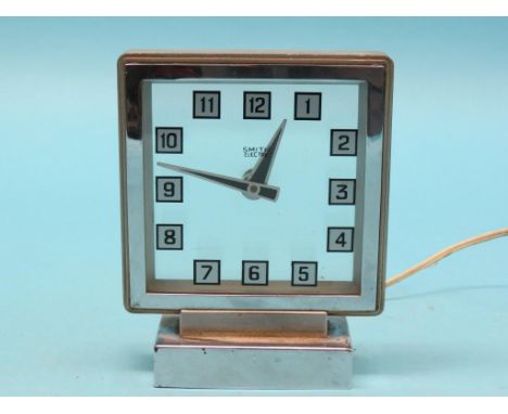A Smith's chromium Mystery clock, square glass dial on stepped chromium base, 8in. high - electric