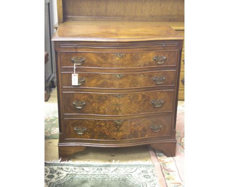 A reproduction burr walnut chest, serpentine-fronted with brushing slide, four graduated drawers beneath, fluted corners, bra