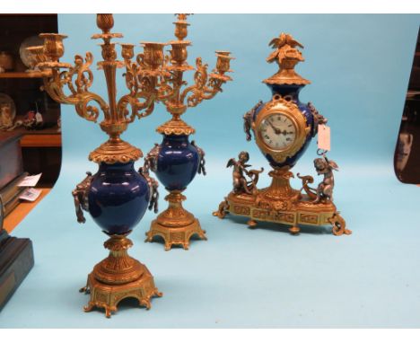 A 19th century-style ormolu and blue ceramic clock garniture, clock with cherub and lion-mask mounts, six-sconce candalabra, 