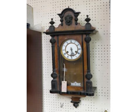 A late 19th century German wall clock, enamelled dial within embossed bezel, gong-striking movement with grid-iron pendulum a