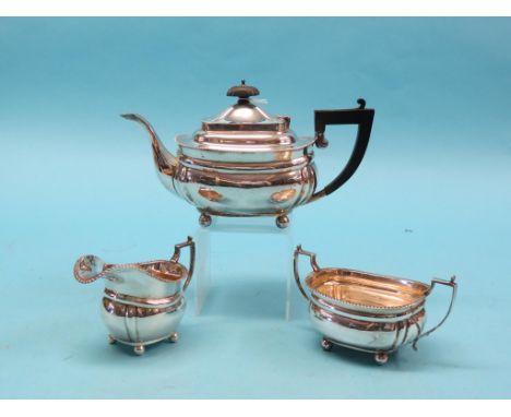 A silver teaset, teapot, twin-handled sugar bowl and milk jug with gadrooned borders, Birmingham 1919, approx. 30oz. gross to