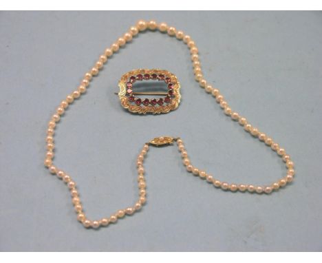 A Victorian engraved yellow metal brooch, rectangular-shape set red stones, and a graduated pearl-type necklace with 9ct. gol