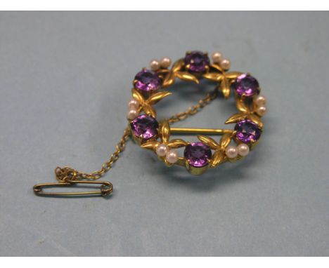 An amethyst and seed-pearl type brooch, circular-shape with 9ct. gold leafage