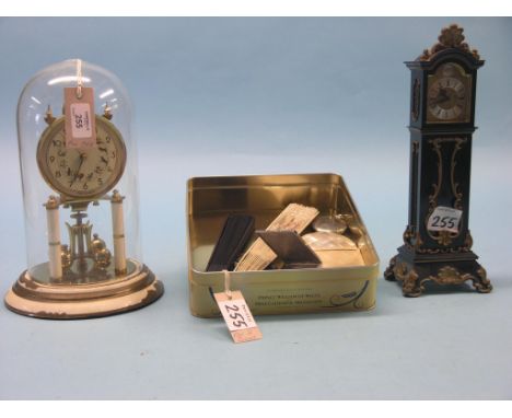 A brass skeleton clock, under glass dome, 11in., and a black and gilt miniature longcase clock, each with pendulum, also to i