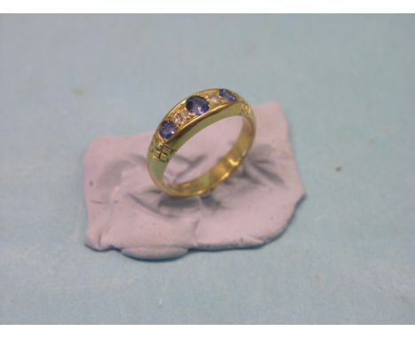 An 18ct. gold, diamond and sapphire ring, three sapphires, two diamonds, size M/N