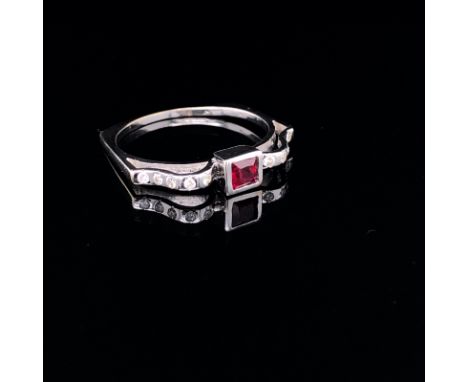 AN 18ct WHITE GOLD UNHALLMARKED RUBY AND DIAMOND RING. THE CENTRAL RUBY PRINCESS CUT IN A RUBOVER SETTING, WITH DIAMOND SET R