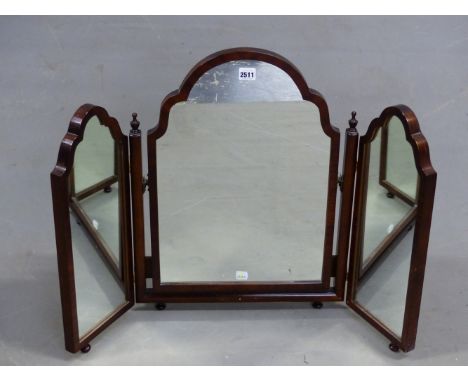 A MAHOGANY TRIPTYCH DRESSING TABLE MIRROR, THE RECTANGULAR FRAMES WITH WAVY ARCH TOPS AND ON KNOB FEET.   H 60 x W 83cms.