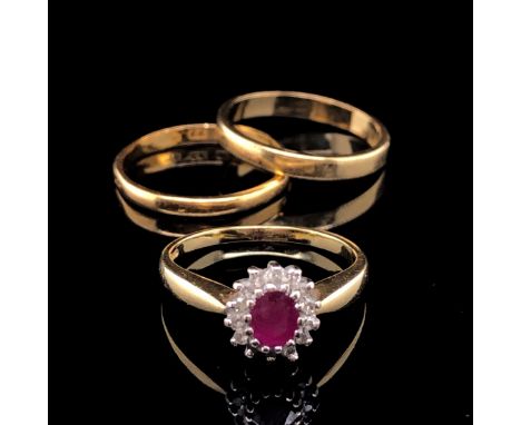 AN 18ct GOLD RUBY AND DIAMOND OVAL CLUSTER RING, FINGER SIZE K, TOGETHER WITH AN 18ct GOLD WEDDING BAND FINGER SIZE L, AND A 