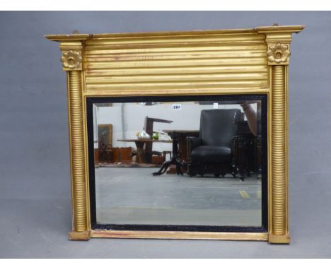 A 19th C. RECTANGULAR MIRROR WITHIN REEDED EBONY SLIP FLANKED BY GILT FLOWER HEAD TOPPED RING TURNED COLUMNS AND BELOW FLUTED