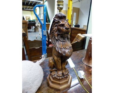 A  TABLE LAMP WITH RED SHADE, THE BASE AS A LION SEATED ON A STEPPED OCTAGONAL BASE. H 40cms. correction to description , thi