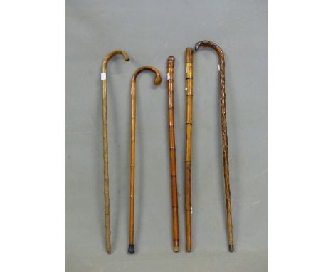 TWO BRASSICA WALKING STICKS, A JAPANESE CARVED BAMBOO CANE, ANOTHER BAMBOO CANE TOGETHER WITH A BAMBOO WALKING STICK