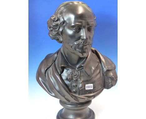 A BLACK PAINTED PLASTER BUST OF SHAKESPEARE WEARING A CLOAK OVER HIS TASSELL TIED SHIRT AND SUPPORTED ON A SOCLE.   H 53cms.