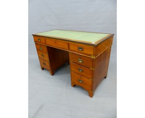 A TEAK CAMPAIGN STYLE PEDESTAL DESK, THE BRASS EDGED RECTANGULAR TOP INSET WITH LEATHER ABOVE THREE APRON DRAWERS, EACH PEDES
