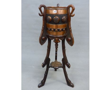 A COPPER COOPERED BARREL PLANTER SUPPORTED BY THREE BRACKETS ABOVE SHAPED LEGS JOINED BY A TIER STRETCHER.   Dia. 27 x H 113c