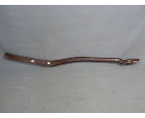 A HARDWOOD BOAT TILLER HANDLE CARVED WITH A DOGS HEAD SCREWS INTO A BRASS RING AT ONE END. W 156cms.