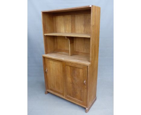 AN ARTS AND CRAFTS STYLE OAK BOOKCASE CABINET IN THE MANNER OF PETER WAALS, WITH SLIDING DOORS TO LOWER SECTION.  RAISED ON S