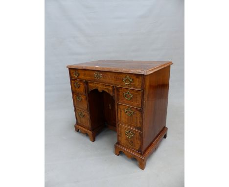 A GEORGIAN WALNUT KNEEHOLE DESK, THE LINE INLAID TOP OVER A LONG DRAWER, THE PEDESTALS EACH WITH THREE DRAWERS ON BRACKET FEE