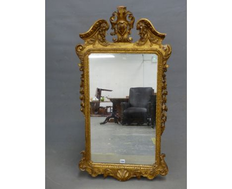 AN 18th.C. STYLE RECTANGULAR MIRROR, THE GILT FRAME WITH FOLIAGE CENTRED BROKEN ARCH PEDIMENT, SWAGGED SIDES AND SHELL CENTRE