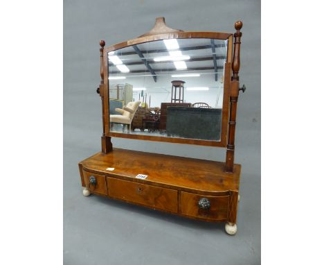 A GEORGE III MAHOGANY RECTANGULAR DRESSING TABLE MIRROR ON A BOW FRONT BOX WITH A CENTRAL DRAWER FLANKED BY TWO WITH LION MAS