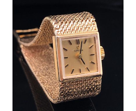 A 9ct GOLD OMEGA LADIES VINTAGE MANUAL WOUND WRIST WATCH, CIRCA 1968. SQUARE CHAMPAGNE DIAL, GOLD BATONS, AND INTEGRAL MILANE