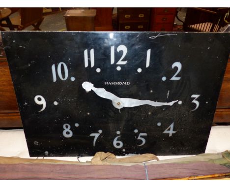 A VINTAGE BLACK PAINTED ALUMINIUM FACED RECTANGULAR WALL CLOCK, THE METAL PIERCED THROUGH WITH ARABIC NUMERALS TO GLASS BELOW