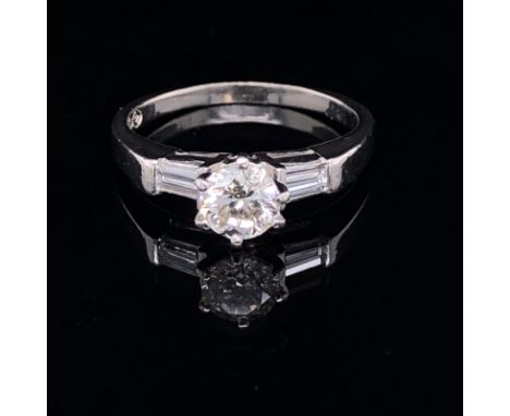 A PLATINUM AND DIAMOND TRILOGY RING. THE CENTRAL DIAMOND APPROX. ESTIMATED WEIGHT 0.70cts, I/SI2/3 SET IN AN OPEN SIDE SIX CL