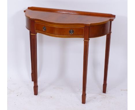 A reproduction serpentine crossbanded yew wood console table, W82cm, H76cm, D37cm 