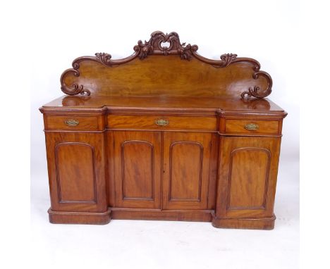 A Victorian mahogany inverted break-front sideboard, with raised carved back, 3 frieze drawers, and arch panel cupboards unde