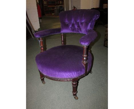 Low mahogany framed bedroom chair on turned legs with castors and purple button back upholstery