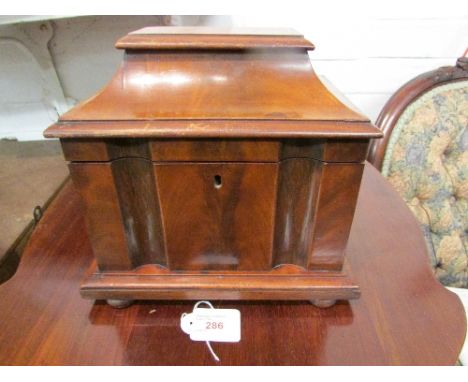 Victorian mahogany tea caddy of sarcophagus shape, the interior lined in pink paper with two lidded compartments, standing on
