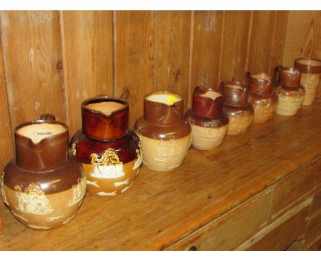 Seven graduating stoneware hunting jugs (18cm to 13cm), one stamped Royal Doulton, five stamped Doulton Lambeth, and one unma