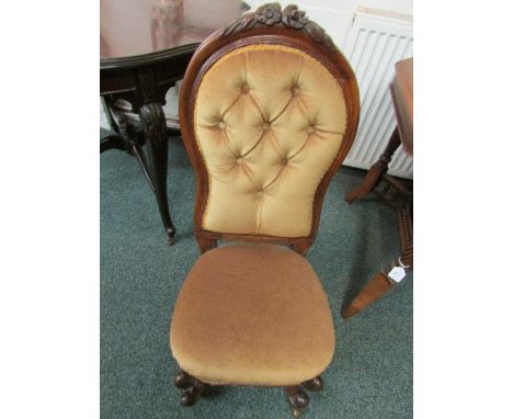 Victorian bedroom chair in gold coloured button back upholstery, the back rail carved with flowers, the front carbriole legs 