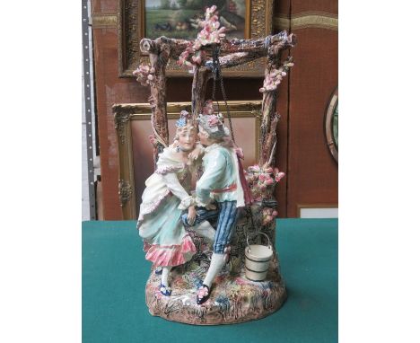CONTINENTAL RELIEF DECORATED CERAMIC FIGURE GROUP DEPICTING A LADY AND GENT BESIDE A WELL, APPROXIMATELY 51cm HIGH 