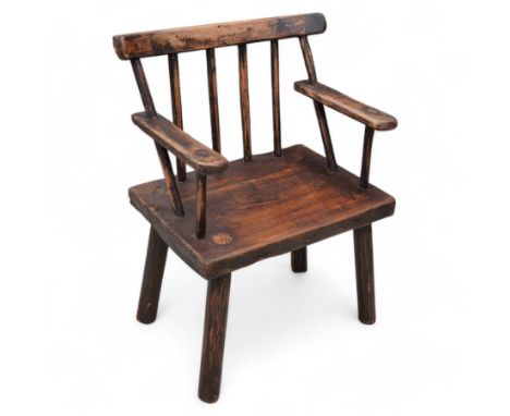 Vernacular 'Irish famine' or 'primitive' pine chair, bar cresting rail over spindle back, flat arms on thick plank seat, roun