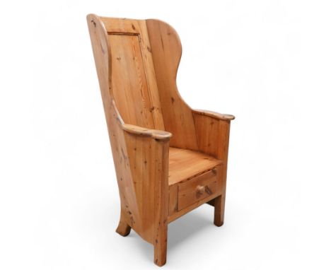 20th century waxed pine lambing chair, winged panelled back, shaped arms enclosing plank seat, fitted with single drawer, on 