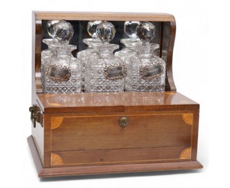 Edwardian walnut and boxwood inlaid tantalus games compendium, having three square section cut glass decanters, with associat