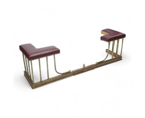 20th century brass telescopic club fender, burgundy upholstered seats with stud bands on turned brass balustrade, on moulded 