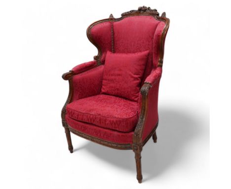 Late 19th century walnut framed fauteuil armchair, arched cresting rail carved with musical instruments and extending floral 