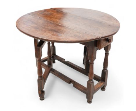 Early 18th century oak table, oval drop-leaf top over single end drawer, gate-leg action base, on turned supports united by s