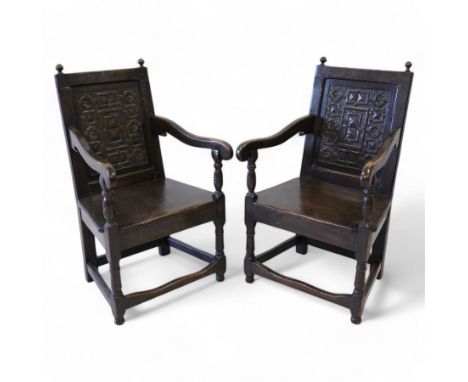 Pair 17th century design wainscot open armchairs, the cresting rail with turned finals over panelled back, the panel carved w