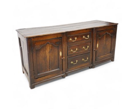 Late 17th to early 18th century oak reverse-breakfront dresser base, the shaped rectangular three-plank top with moulded edge