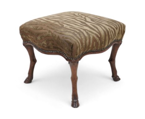 Victorian walnut footstool, the over-stuffed seat upholstered in dark green animal print fabric with stud band, on carved dee